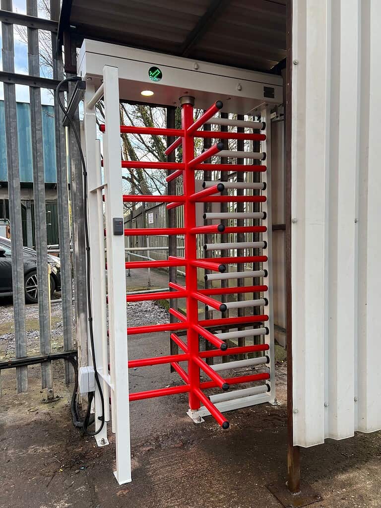 Security turnstile with red bars at Meridian Integrated Systems facility.