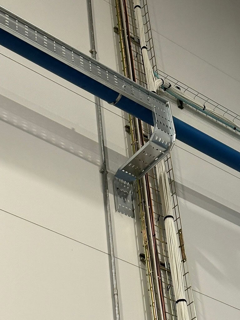 Industrial cable management and conduit installation in a warehouse setting.