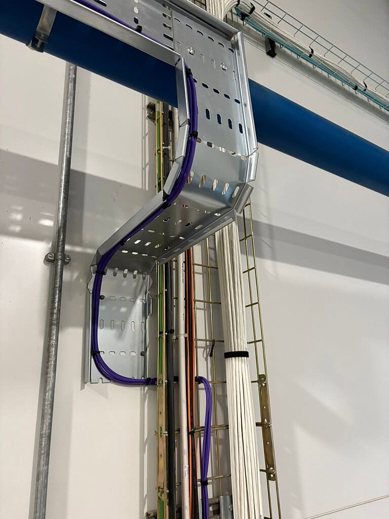 Industrial piping and cable management system at Meridian Integrated Systems facility.